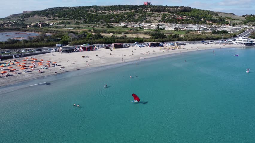 Malta Aerial, white sand beach with umbrelas in November. Approaching roundabout near Ghadira Nature reserve. High quality 4k footage