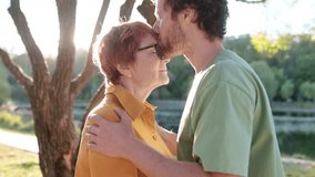 Loving adult son tenderly embracing and kissing his joyful elderly mother while walking in an autumn park. Happy meeting of mom and grown child. Family relationships between adult children and parents - Powered by Shutterstock - Get 15% off with code: PIKWIZARD15