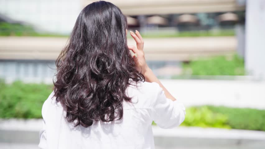 pretty young asian woman looking back at camera smile in the urban city sunny summer day