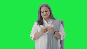 Happy Indian senior businesswoman counting money Green screen - Powered by Shutterstock - Get 15% off with code: PIKWIZARD15
