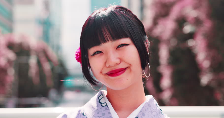 Japanese girl, face and kimono in city with fashion, confidence and pride for culture. Woman, happy or portrait in urban Tokyo with traditional attire, heritage or indigenous style with smile in town