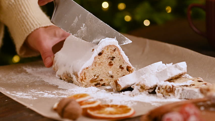 Sliced of Christmas stollen on wooden background. Traditional Christmas festive pastry dessert. Stollen is treat for Christmas