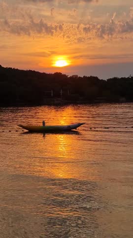 As the sun sets on the horizon, vibrant hues of orange and gold dance across the still water. A solitary kayak floats serenely, echoing the tranquility of the lakeside ambiance. Rovinj Croatia
