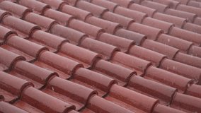 Heavy rain pours onto red roof tiles, creating glistening water trails and rhythmic splashes across the surface during a strong downpour - Powered by Shutterstock - Get 15% off with code: PIKWIZARD15