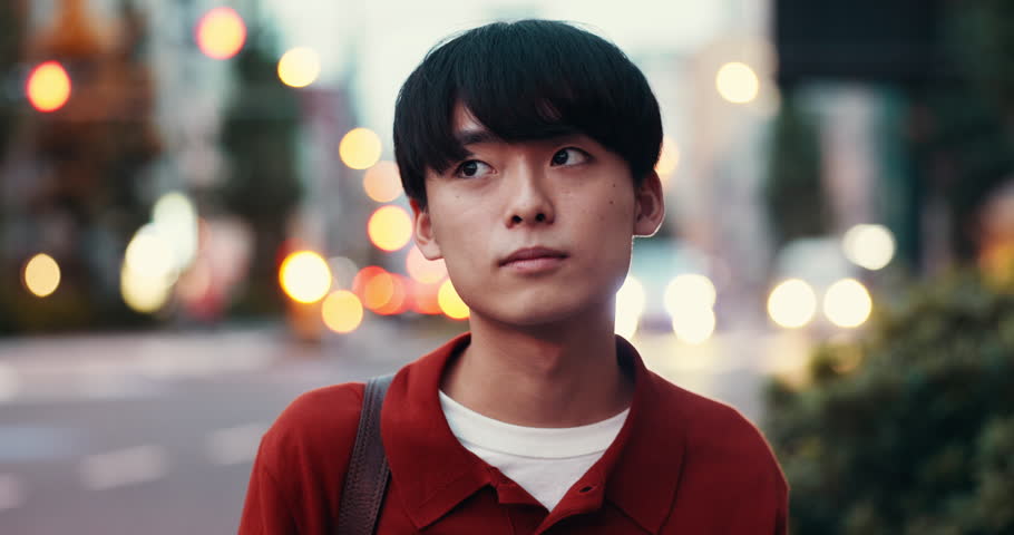 Face, funny and Japanese man in city, night and smile with confidence, urban town and laughing. Portrait, Asian person and guy in street, evening and pride with humor, travel and calm with joy