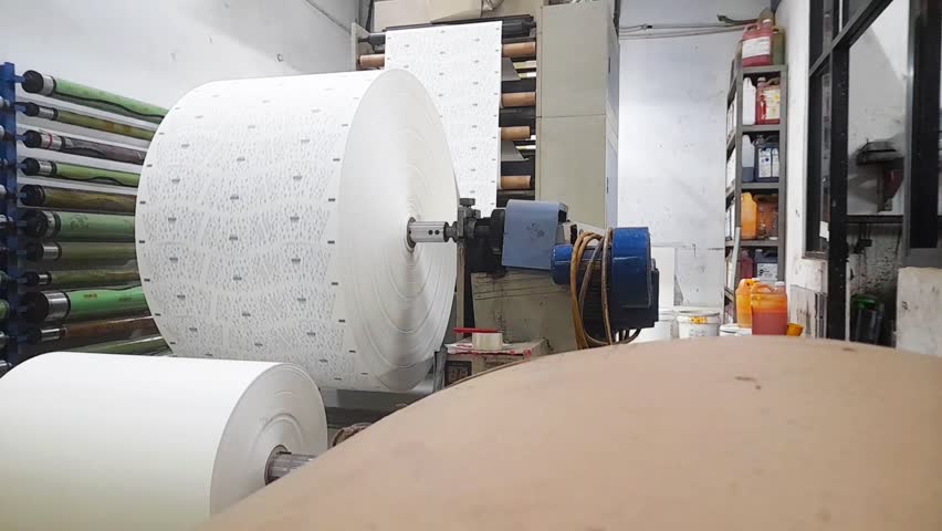 Machines in paper mill factory. The process of producing designs on paper. Paper cup manufacturing factory.