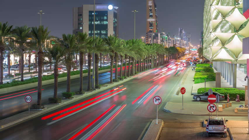 Aerial night timelapse of King Fahd Road in Riyadh, Saudi Arabia. Bustling busy traffic with cars near the illuminated Riyadh National Library, surrounded by modern towers and skyscrapers