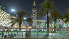 Perspective night timelapse of the King Fahad National Library's illuminated facade with palms and glowing tower in view. People walk across the vibrant square in downtown Riyadh, Saudi Arabia. - Powered by Shutterstock - Get 15% off with code: PIKWIZARD15