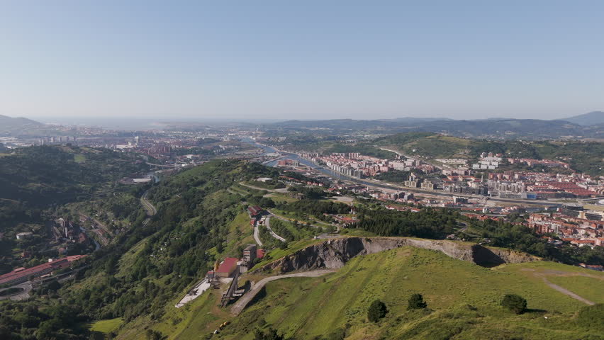 An aerial footage of the Mount Cobetas, raises between the neighborhoods of Altamira and Zorroza on a sunny day in Bilbao city, Biscay, Spain