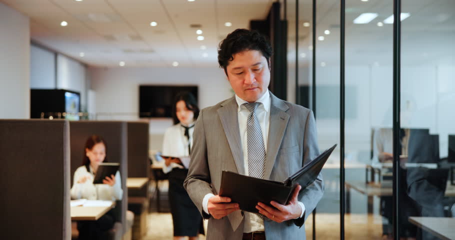 Businessman, Japanese and reading in paperwork for contract, agreement or proposal for planning. Male person, walking and documents as trading portfolio, investment or stock market in office building
