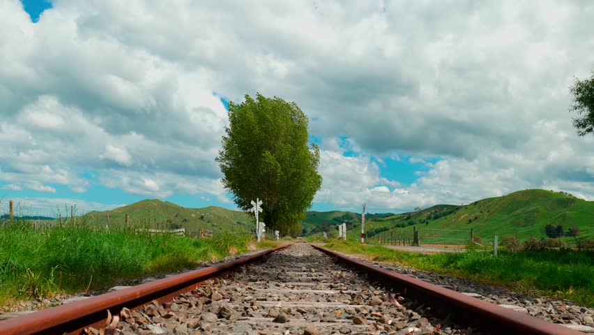 A scenic view of a railway line stretching through the landscape, surrounded by nature, with tracks leading into the distance.