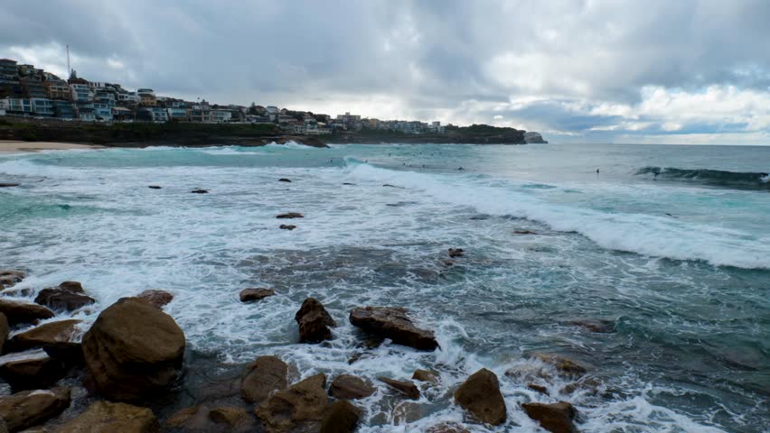 Surfers catching waves at Bronte Beach, with the stunning coastal scenery, clear waters, and vibrant surf culture in the background.