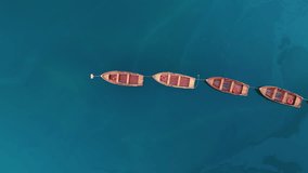 Wooden rowboats float in a straight line on the turquoise water of Lake Braies in Italy, aerial view - Powered by Shutterstock - Get 15% off with code: PIKWIZARD15