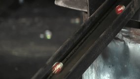 Molten Marbles on a Metal Slide in a Manufacturing Process, Molten Glass Marbles Rolling Down a Metallic Conveyor - Close Up - 4K - Powered by Shutterstock - Get 15% off with code: PIKWIZARD15