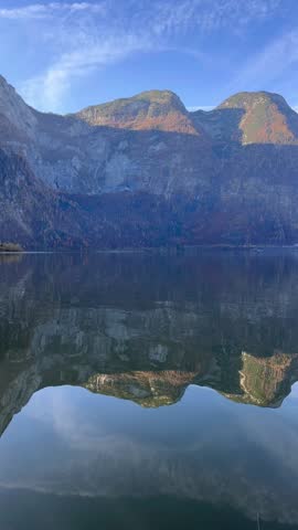 vertical view of lake waters. Fresh air, blue sky along the horizon, mountain skyline, picturesque fishing villages Famous tourist region. Austria