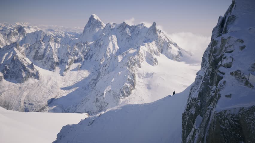 The Mont Blanc massif stretches in the background, with a mountaineer carrying skis on his back, ready to tackle the challenging terrain of this iconic alpine region.