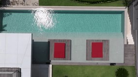 Drone point of view of modern porch of a house with swimming pool. Modern Infinity Pool Tiled Stone Terrace Drone Directly Above View, Modern Architecture Green Energy Luxury Home with Infinity Pool - Powered by Shutterstock - Get 15% off with code: PIKWIZARD15