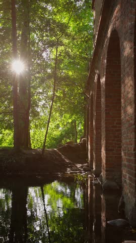 old ancient aqueduct in romantic Arcadia park, antique Roman architecture made of brick wall, historical building, Poland, vertical video 4k