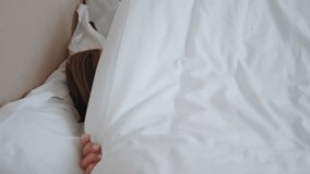 Sleepy woman covering face hiding with blanket at morning closeup. Lazy girl waking up enjoying at soft pillows. Relaxed lady awakening in cozy room. Dreamy model lying bed resting at light apartment  - Powered by Shutterstock - Get 15% off with code: PIKWIZARD15