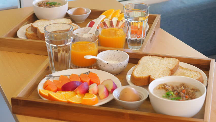 Healthy breakfast served on wooden trays with fresh fruits, orange juice, and toast, Enjoying nutritious morning meal at home, Balanced Diet and Healthy Living.