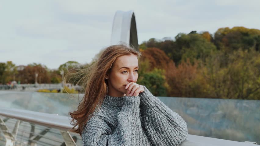A thoughtful and contemplative woman finds herself in a serene autumnal setting