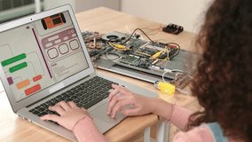 Back view of american girl coding engineering prompt while laptop screen display programing software to generate AI at table with mother board. Smart attractive student working on computer. Pedagogy. - Powered by Shutterstock - Get 15% off with code: PIKWIZARD15
