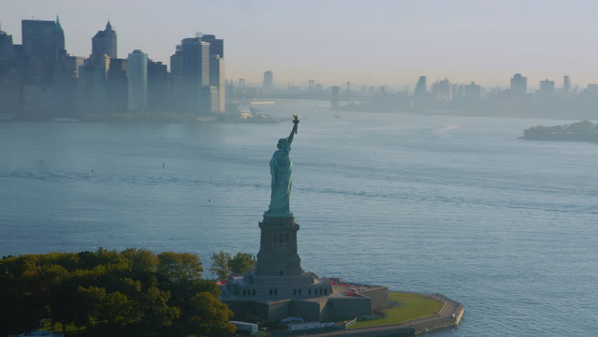 
High Quality Aerial Orbit of Statue of Liberty in Liberty Island. Manhattan and New Jersey Skyline with dense fog.  New York City Famous Landmark. Shot From Helicopter.