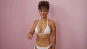Young hispanic woman in bikini gesturing small size with fingers, smiling confidently, standing over isolated pink background - measurement concept - Powered by Shutterstock - Get 15% off with code: PIKWIZARD15