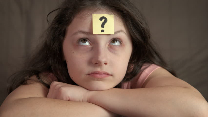 Child forehead with question sticker. A view of young girl forehead with question sign sticker.
