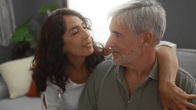 Middle-aged couple embracing lovingly in a cozy living room setting showcasing emotions between man and woman enjoying tender moments indoors. - Powered by Shutterstock - Get 15% off with code: PIKWIZARD15