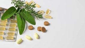 Pills with rosemary and sage leaves on white - Powered by Shutterstock - Get 15% off with code: PIKWIZARD15