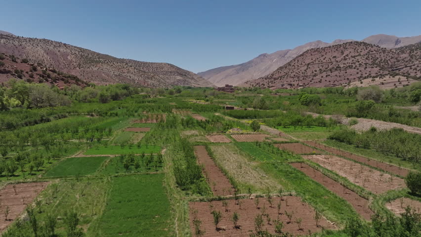 Lush green agricultural valley surrounded by arid mountains
