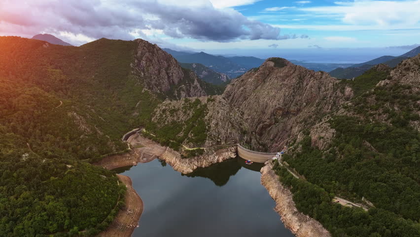 Explore the breathtaking beauty of Barrage de Tolla in Corsica with stunning views of nature and the serene reservoir during sunset