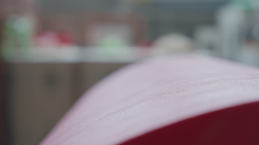 Close-up of red eco fabric material used for manufacturing of shopping bags. Ecologically sustainable fabric material for accessory production. Roll of the eco fabric material for handbag production.