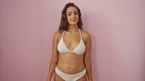 Woman in colorful bikini on isolated pink background showing small size with fingers, young, hispanic, hand gesture, size concept and confidence - Powered by Shutterstock - Get 15% off with code: PIKWIZARD15