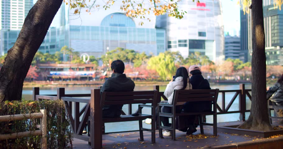 People Sitting on Bench at Seokchon Lake Park during Autumnal Sunny Day in South Korea