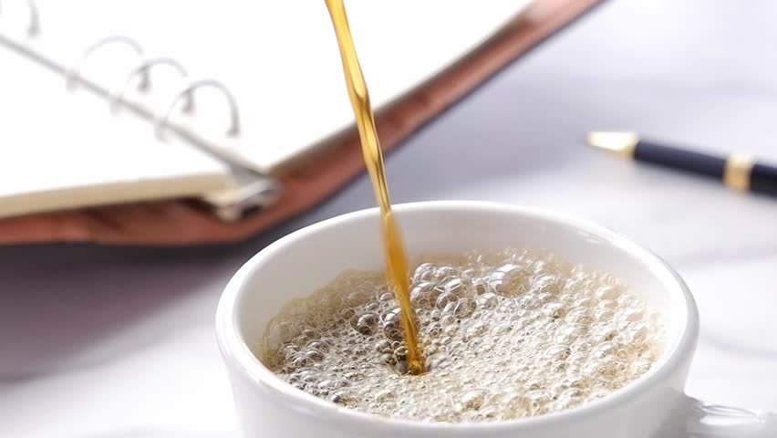 Pouring fresh and delicious coffee into coffee cup at the office, Slow Motion