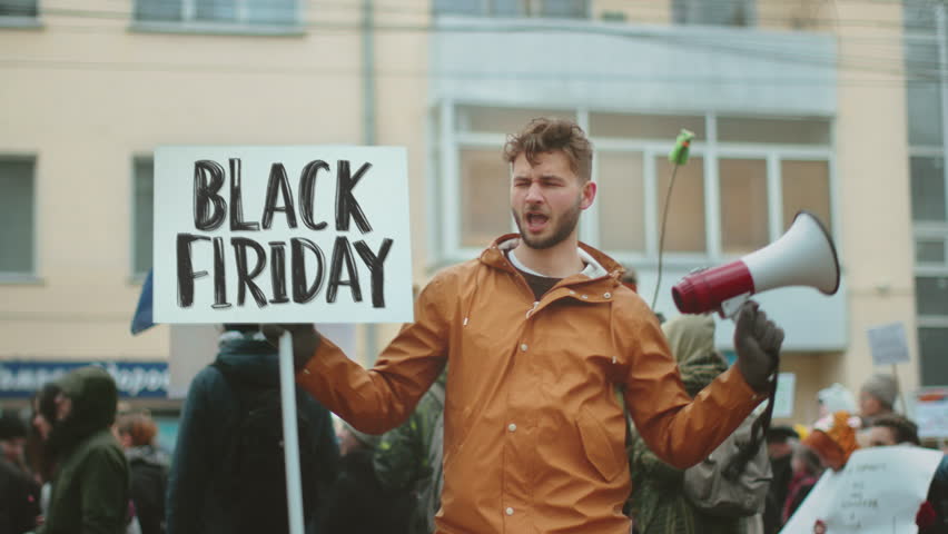 Funny man hold black Friday flash sale banner city street. Crazy male person wave big special offer promo placard. Promotion poster mock up. Joy fun guy show seasonal ad. Hot price off day. Red advert