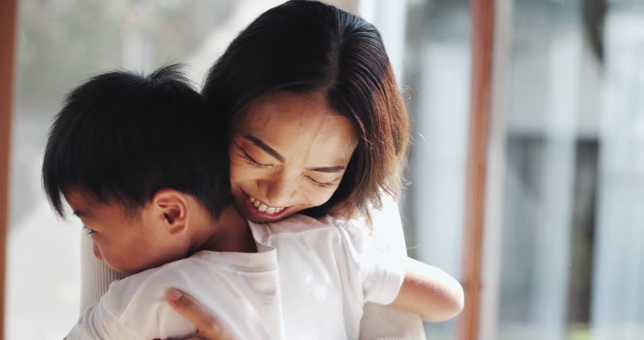Happy, hug and Asian mom with child in home for bonding, love and healthy relationship by window. Family, childhood and Japanese mother with boy embrace for affection, care and support in house