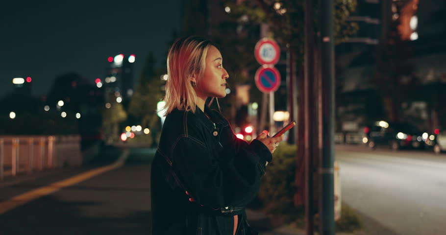 Night, phone and Asian woman in city on location, street road or holiday adventure journey in Tokyo. Tourist, sidewalk or confused Japanese girl on mobile app for travel, navigation or map in Japan