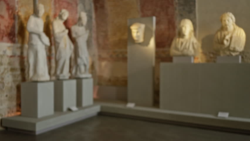 Blurry roman sculptures in museum exhibit with defocused background display ancient art indoors enhancing stone texture focus