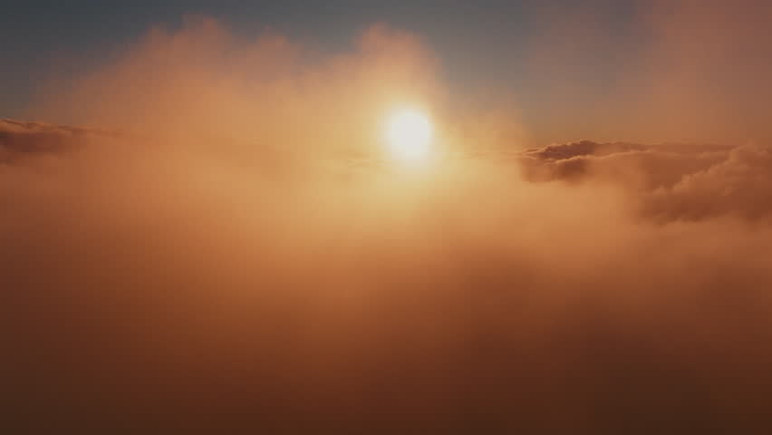 Panoramic high altitude aerial view above atmospheric clouds during sunrise