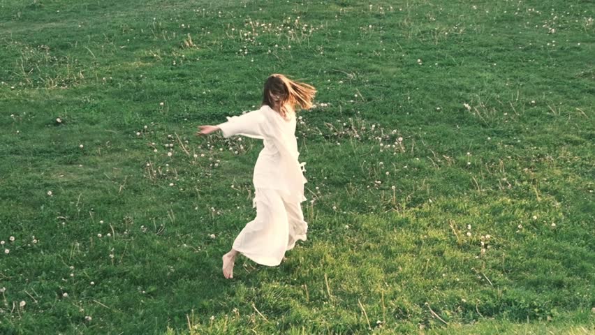 serene moment in a field as the woman dances with graceful, flowing movements, blending freedom, nature, and expression. Her dance conveys a sense of liberation and peace in the open air.