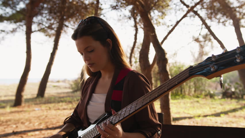 Girl Plays The Bass Instrument In The Countryside In Summer