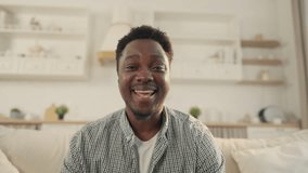 Portrait of cheerful young adult black man talking by video call from home. Happy African American male person smiling kindly, shy and positive student, distant online communication, modern technology - Powered by Shutterstock - Get 15% off with code: PIKWIZARD15