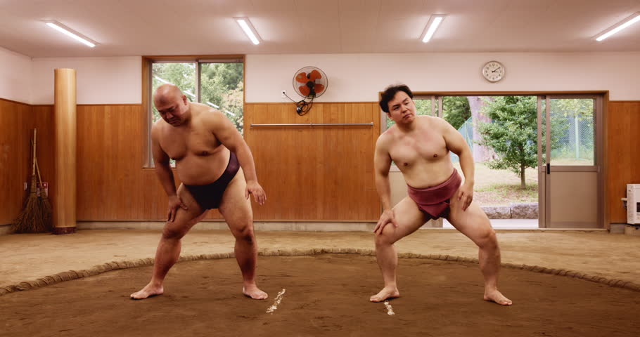 Stretching, sumo and tournament with Japanese people in arena for training, shiko ritual and wrestling. Festival, competition and game with asian men in dohyo ring of temple for culture and sports