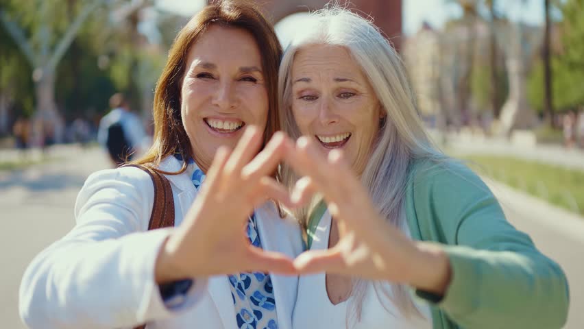 Beautiful senior women bonding outdoors in the city - Attractive cheerful mature female friends having fun, shopping and bonding, concepts about elderly lifestyle	