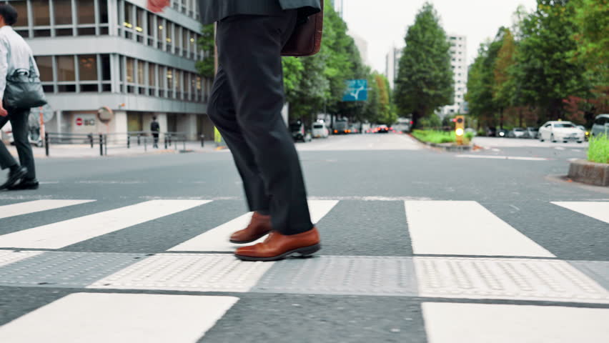 Businessman, legs and crossing street in city for travel, journey and morning commute to work. Japanese person, feet and walking route on Tokyo road with commitment, steps and eco conscious employee