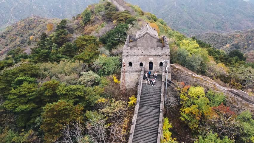 Aerial view of the Great Wall of China with a watchtower, autumn color leaves and mountains landscape in the background in the Huairou area, near Beijing, China