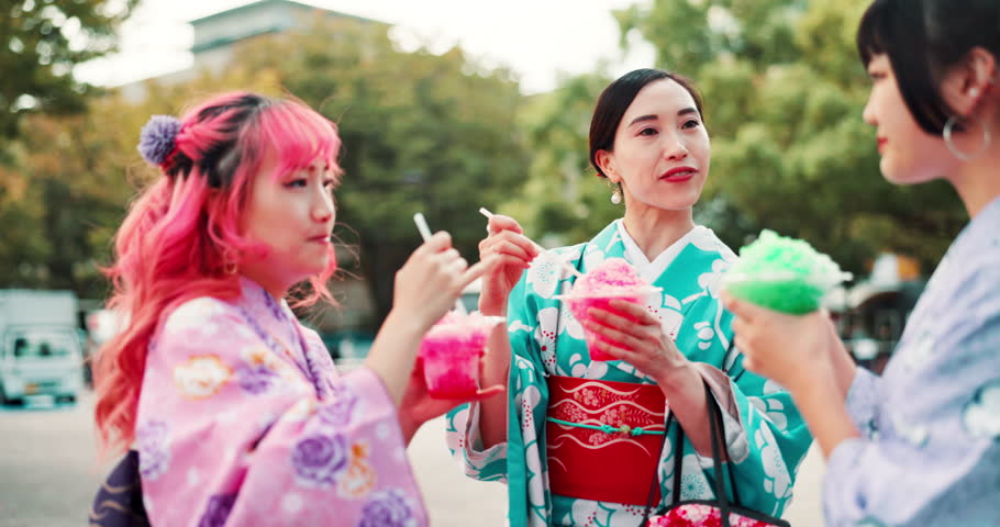 People, park and eating dessert at Japan festival with shaved ice slush drink, taste test and enjoyment in kimono. Traditional fashion, women and friends with kakigori for snack, talking and culture